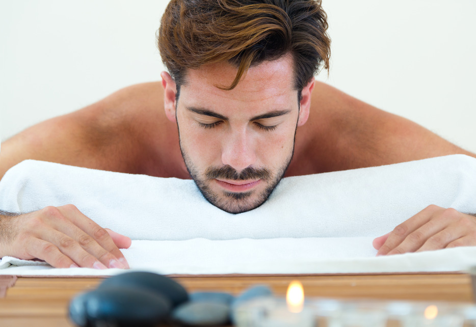 Portrait of masseur doing massage on man body in the spa salon.